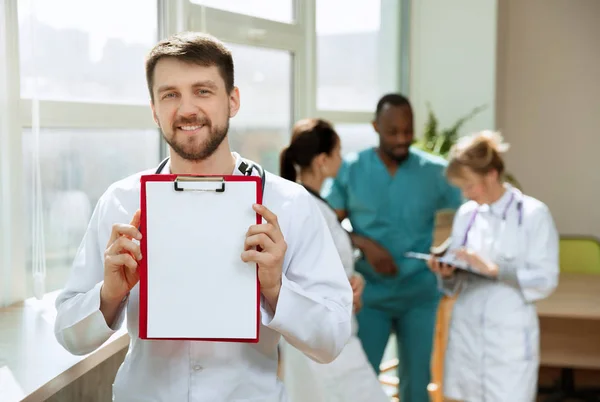 Hermoso médico sonriente sobre el fondo del hospital —  Fotos de Stock