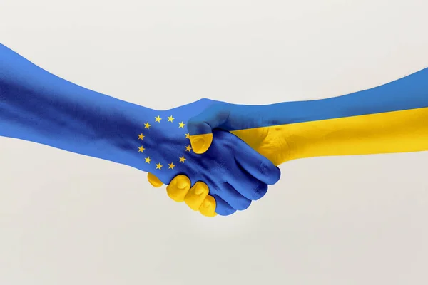 Deux mains. Drapeau de l'Union européenne. Drapeau de l'Ukraine . — Photo