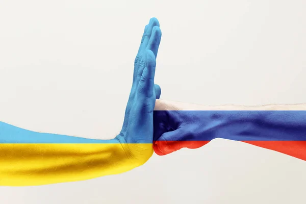 Дві руки. Прапор Російської Федерації. Прапор України. — стокове фото