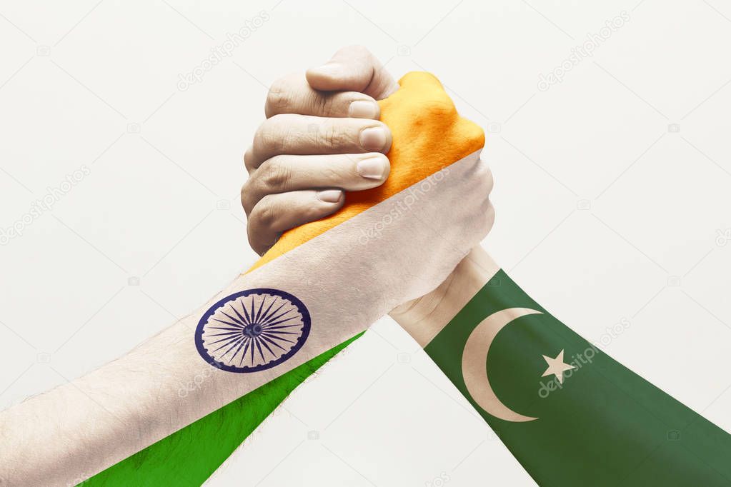 Two male hands competing in arm wrestling colored in Pakistan and India flags