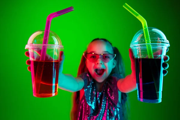 La chica adolescente feliz de pie y sonriendo contra las luces verdes de fondo . — Foto de Stock