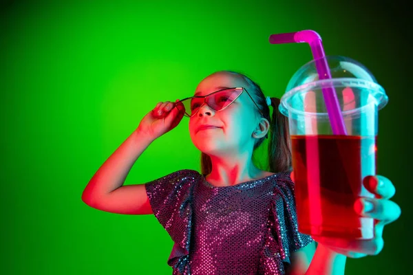 De gelukkige tiener meisje staan en glimlachen tegen groene lichten achtergrond. — Stockfoto