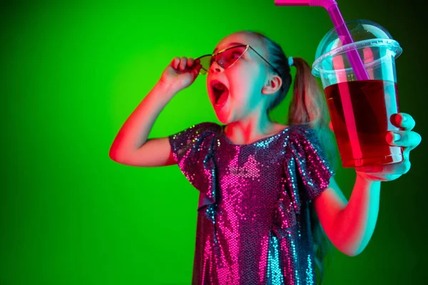 De gelukkige tiener meisje staan en glimlachen tegen groene lichten achtergrond. — Stockfoto