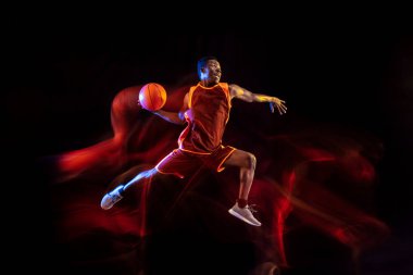 Siyah arka planda genç basketbolcu