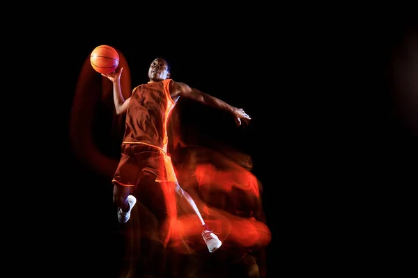 Jovem jogador de basquete contra fundo escuro — Fotografia de Stock