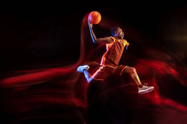 Jovem jogador de basquete contra fundo escuro — Fotografia de Stock