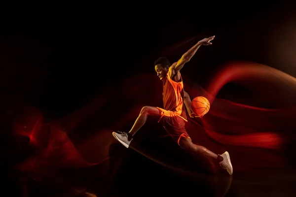 Jovem jogador de basquete contra fundo escuro — Fotografia de Stock