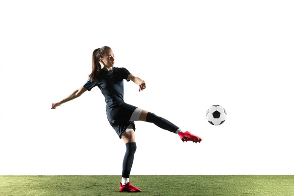 Футболистка пинает мяч на белом фоне — стоковое фото
