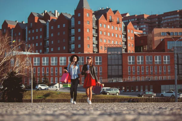 Due ragazze che camminano con lo shopping per le strade della città — Foto Stock