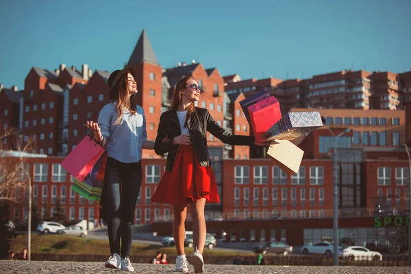 Due ragazze che camminano con lo shopping per le strade della città — Foto Stock