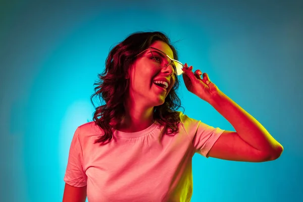 Jovem feliz de pé e sorrindo contra o fundo azul — Fotografia de Stock