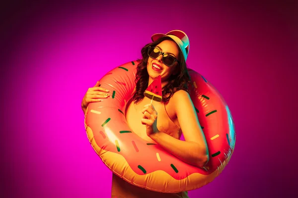 Feliz joven mujer de pie y sonriendo sobre fondo rosa — Foto de Stock