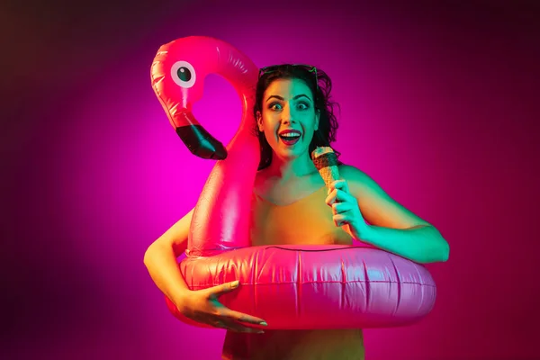 Glückliche junge Frau vor rosa Hintergrund stehend und lächelnd — Stockfoto