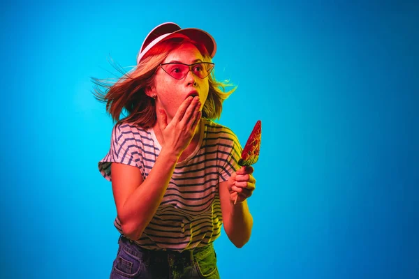 Krásná žena v neonové světelné izolaci na pozadí modrého studia — Stock fotografie