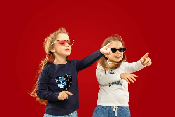 Красиві емоційні маленькі дівчата ізольовані на червоному тлі — стокове фото