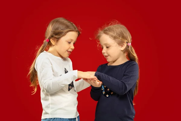 Belles petites filles émotionnelles isolées sur fond rouge — Photo