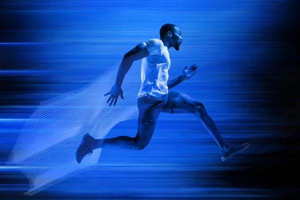 Joven afroamericano corriendo aislado sobre fondo de estudio azul — Foto de Stock