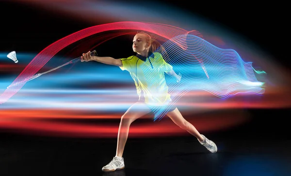 Young girl playing badminton over dark background — 스톡 사진
