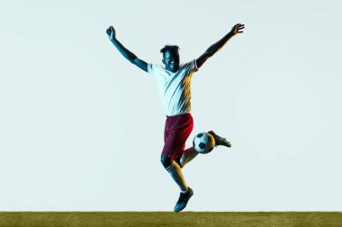 Erkek futbolcu tekme topu beyaz arka plan üzerinde izole