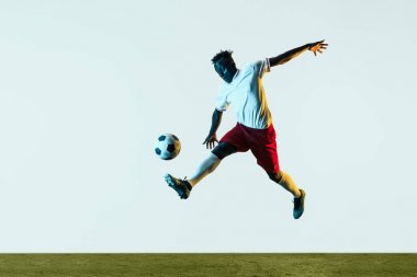 Erkek futbolcu tekme topu beyaz arka plan üzerinde izole