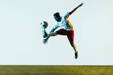 Erkek futbolcu tekme topu beyaz arka plan üzerinde izole