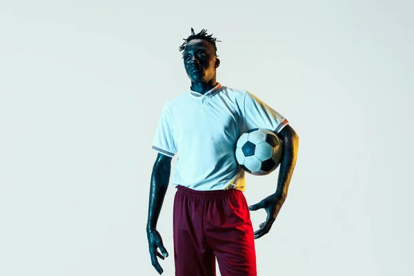 Erkek futbolcu beyaz arka plan üzerinde izole topu ile ayakta — Stok fotoğraf