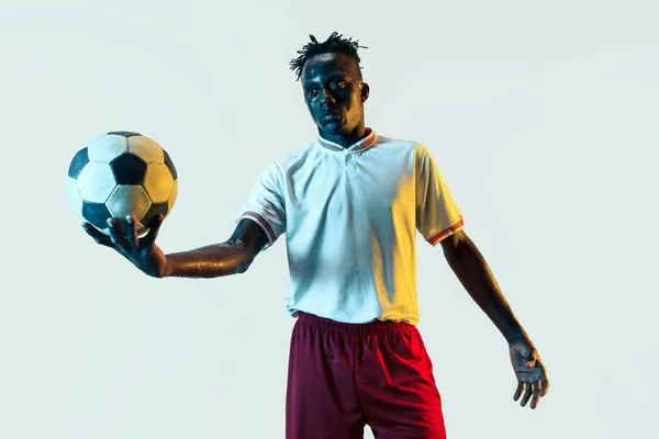 Мужчина футболист, стоящий с мячом на белом фоне — стоковое фото