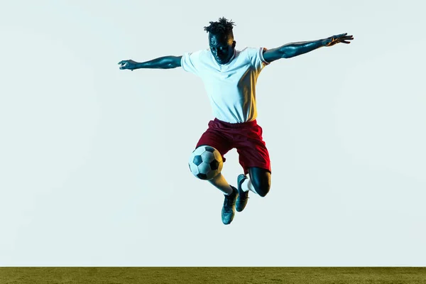 Erkek futbolcu tekme topu beyaz arka plan üzerinde izole — Stok fotoğraf