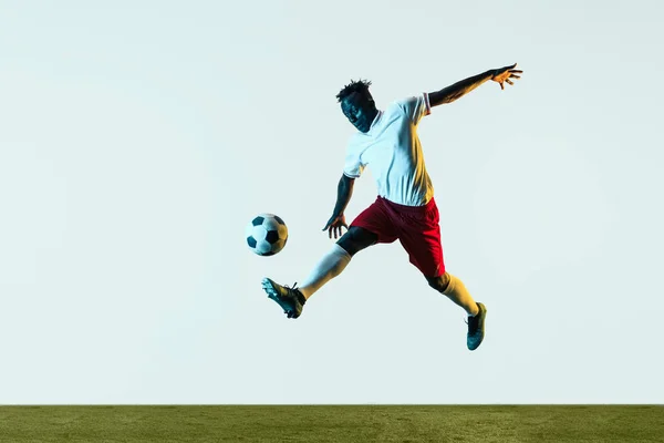 Jugador de fútbol masculino pateando pelota aislado sobre fondo blanco — Foto de Stock