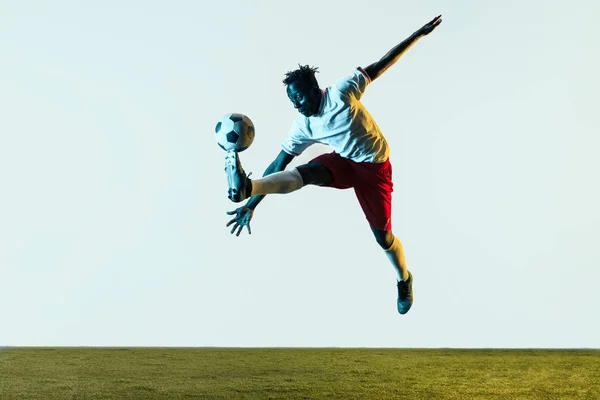 Male soccer player kicking ball isolated on white background — Stock Photo, Image