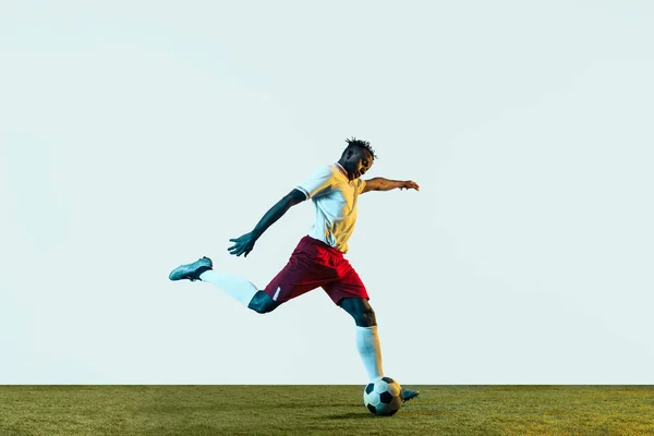 Male soccer player kicking ball isolated on white background — Stock Photo, Image