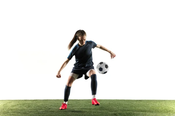 Female soccer player kicking ball isolated over white background