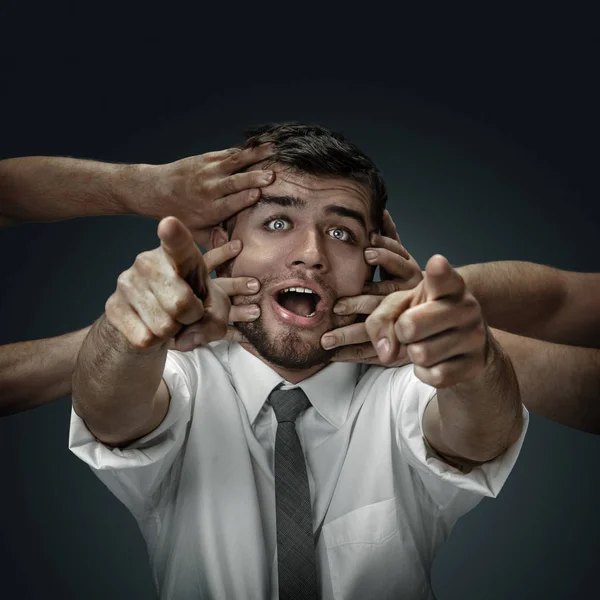 A young man surrounded by hands like his own thoughts — Stock Photo, Image