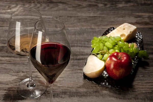 Una bottiglia e bicchieri di vino rosso e bianco con frutta — Foto Stock