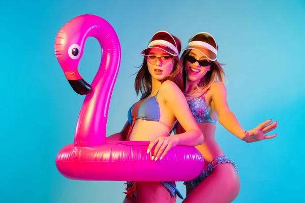 Hermosas chicas aisladas en el fondo del estudio azul en luz de neón — Foto de Stock