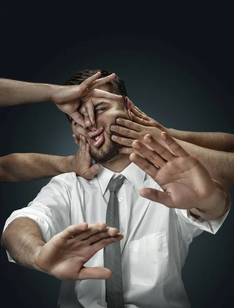 A young man surrounded by hands like his own thoughts — Stock Photo, Image