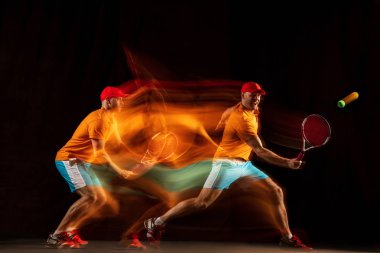 Siyah arka planda tenis oynayan bir beyaz adam