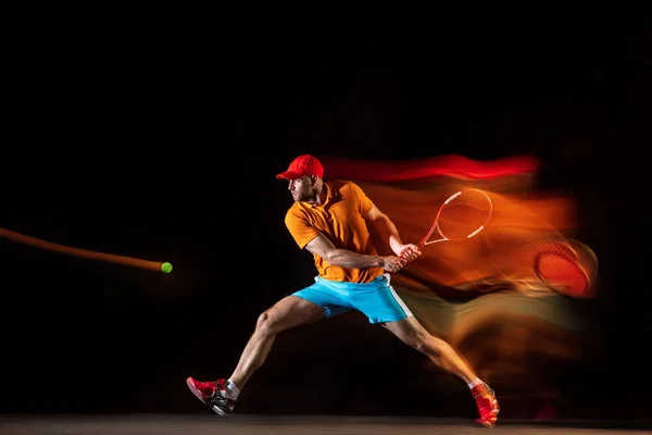 Один кавказький чоловік грає в теніс на чорному тлі — стокове фото