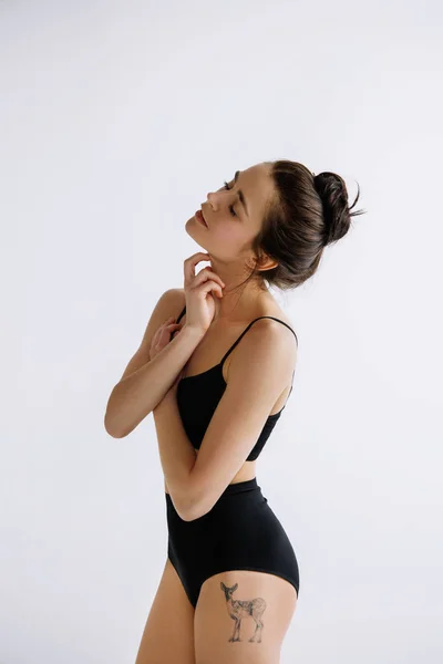Young female ballet dancer against white studio background — 스톡 사진