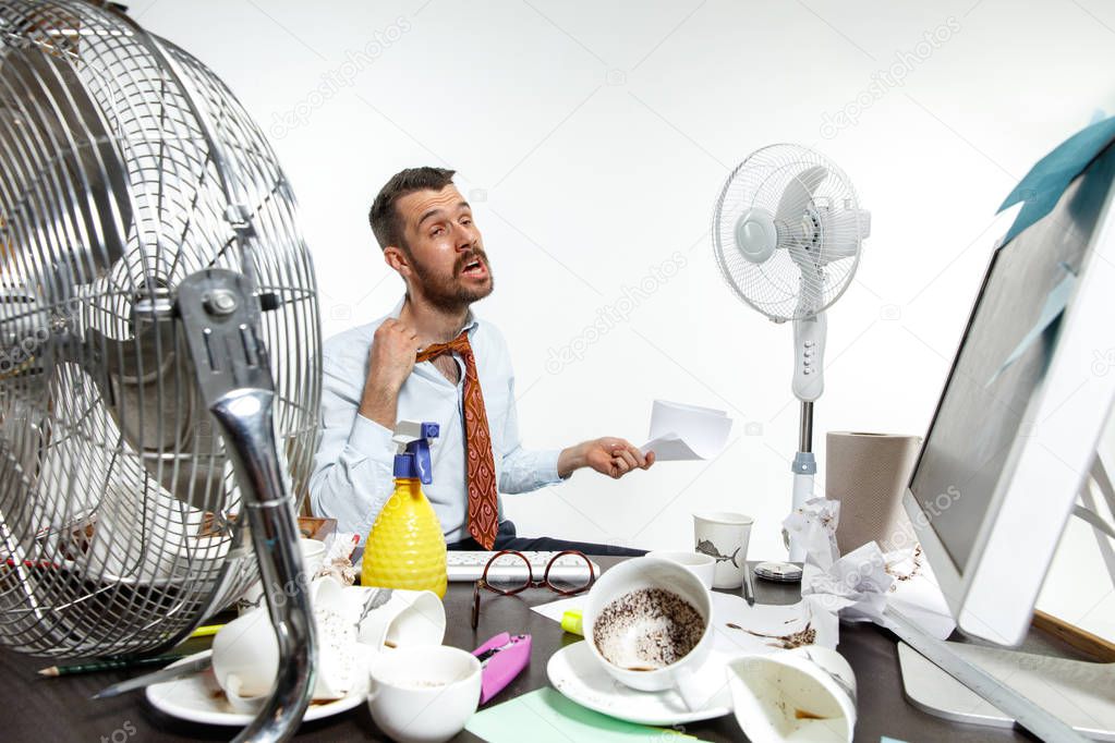 Young man ssuffering from the heat in the office