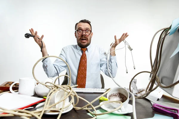 Young man tangled in wires on the workplace — Stock Photo, Image