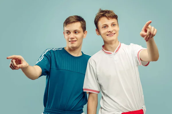 Twee jonge mannen geïsoleerd op blauwe achtergrond — Stockfoto