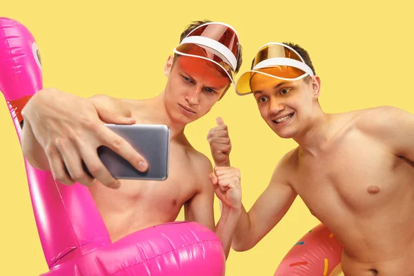 Two young men isolated on yellow studio background — Zdjęcie stockowe