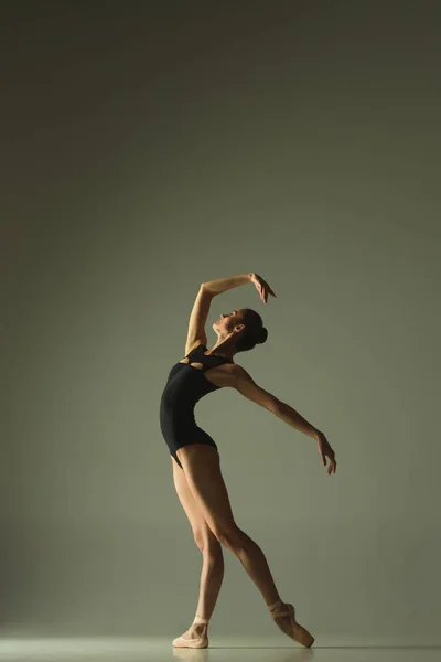 Ung graciös kvinnlig balettdansare som dansar i blandat ljus — Stockfoto