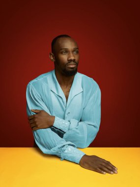 Kırmızı arka planda ortaçağ ihtişamı gibi genç bir adam