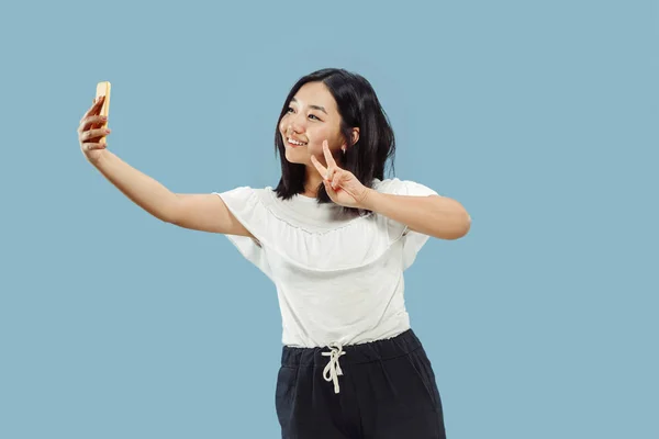 Retrato de meia-comprimento da jovem coreana no fundo azul — Fotografia de Stock