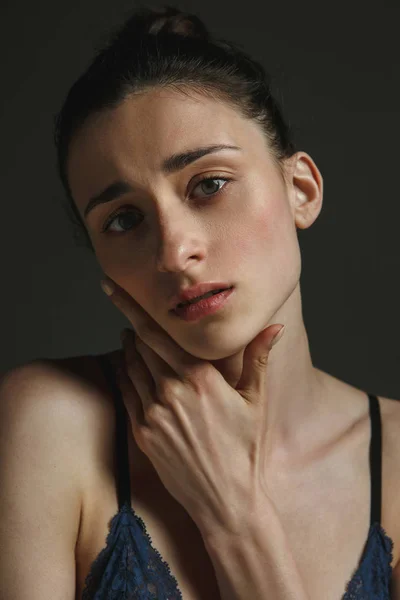 Halblanges Porträt einer jungen, traurigen Frau auf dunklem Studiohintergrund — Stockfoto