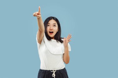 Mavi arka planda Koreli genç bir kadının yarım boy portresi.