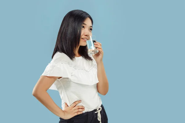 Retrato de media longitud de mujer joven coreana sobre fondo azul — Foto de Stock