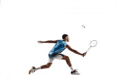 Küçük çocuk badminton oynarken beyaz stüdyo arka plan izole